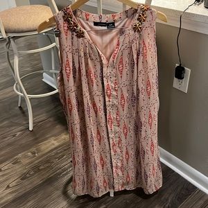 Sleeveless dress with gold flower trim.